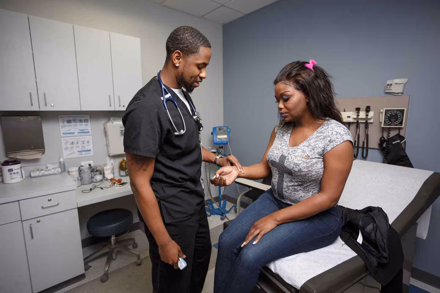 a doctor checking a patients pulse in a clinic